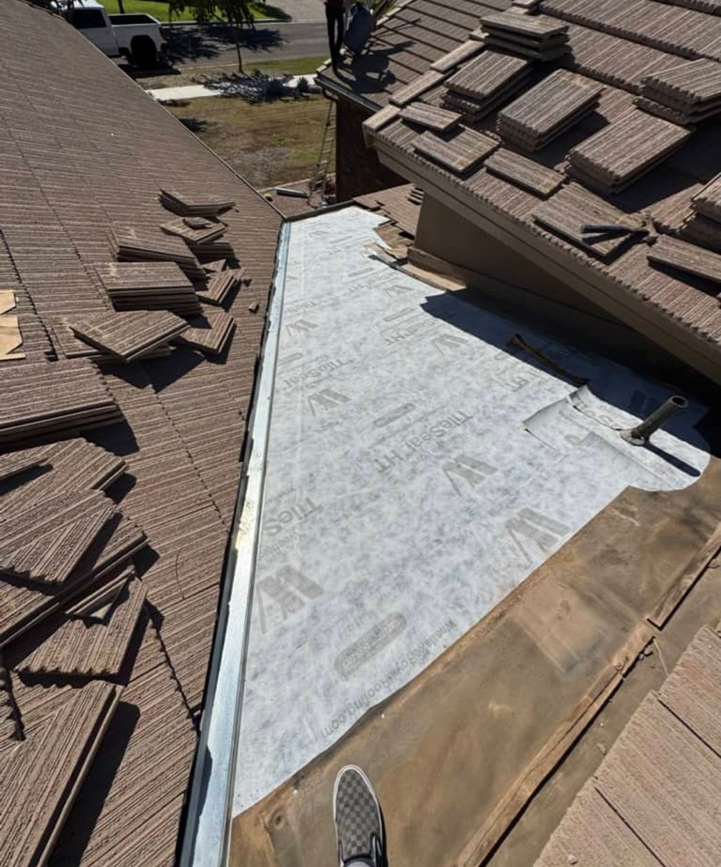 Roofer sweeping off debris from a tiled roof