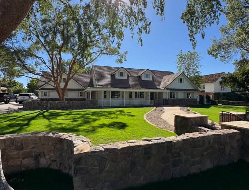 Worker installing metal roofing on residential building exterior