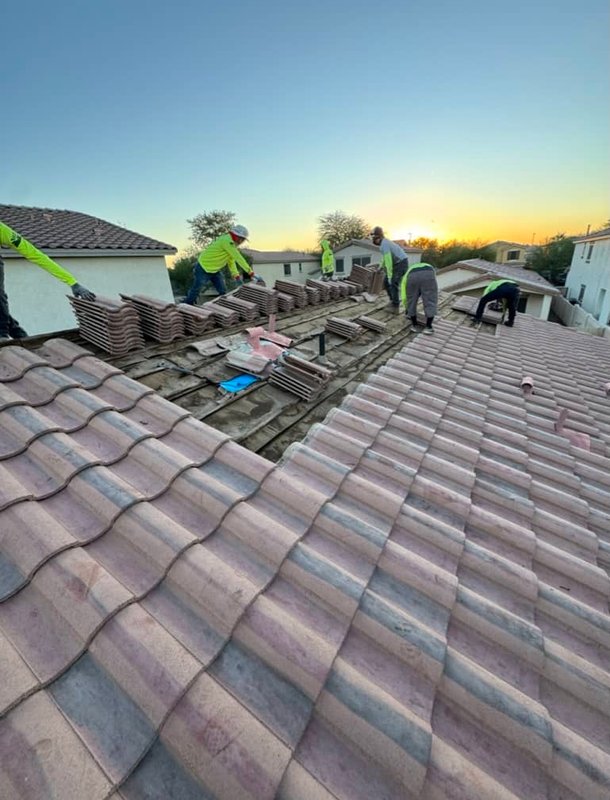 Roofer installing dark metal panels on residential roof